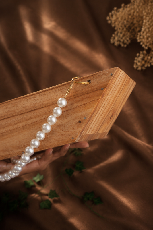 Boat-Shaped Wooden Structure with White Malas and Big Jump Rings
