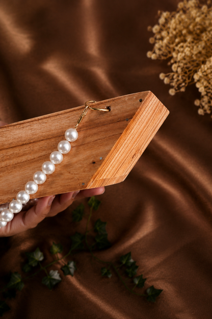 Boat-Shaped Wooden Structure with White Malas and Big Jump Rings