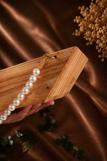 Boat-Shaped Wooden Structure with White Malas and Big Jump Rings