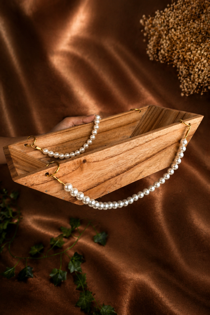 Boat-Shaped Wooden Structure with White Malas and Big Jump Rings